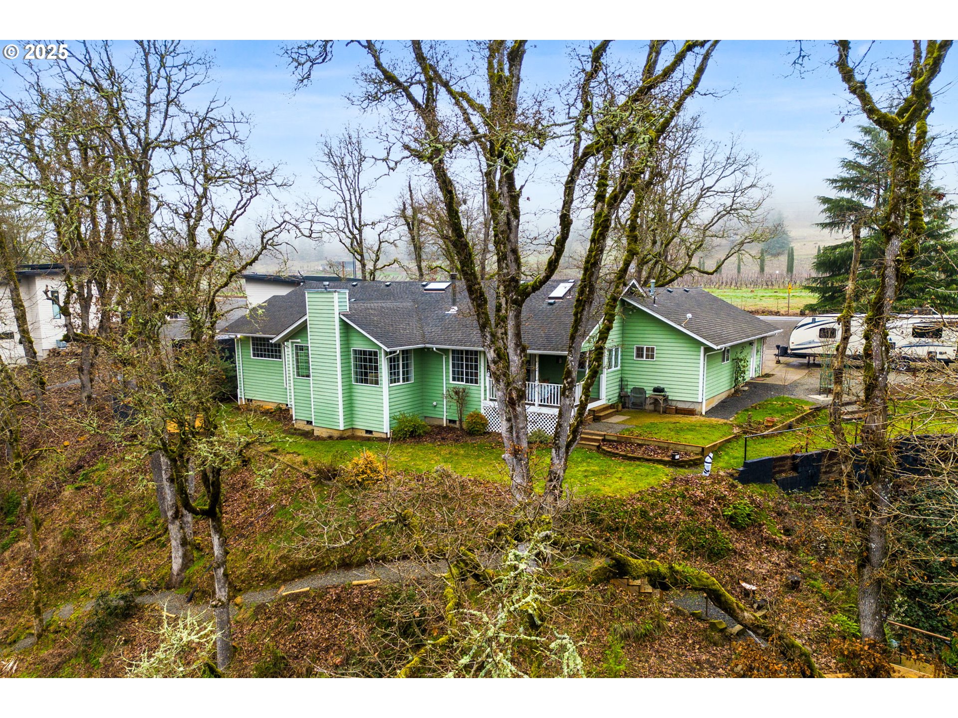 17576 North Abiqua Road Silverton, OR 97381 - Photo 37 of 40 a backyard of a house with table and chairs under an umbrella