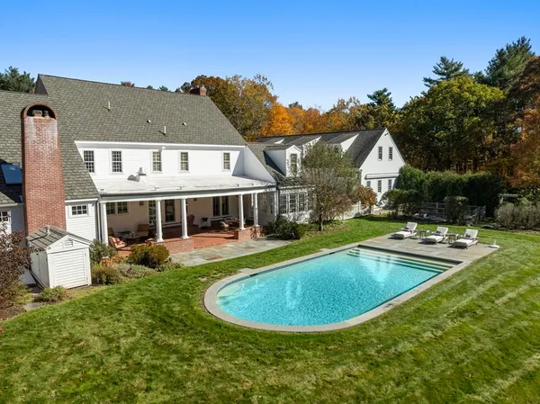 a view of a house with pool fire pit and a yard
