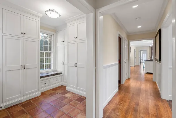 a view of a hallway with wooden floor and cabinet