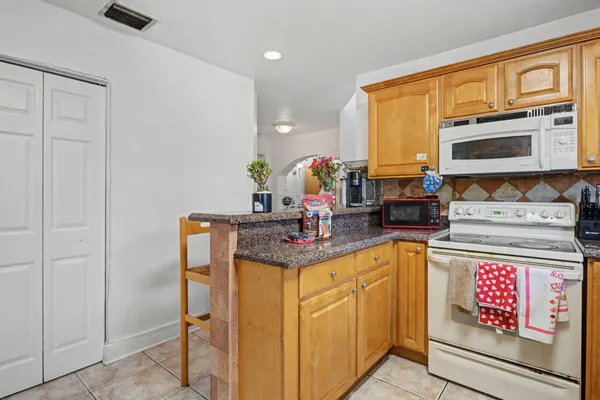 a kitchen with stainless steel appliances granite countertop a sink stove and cabinets