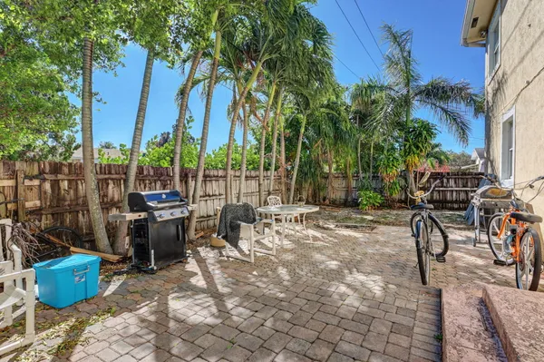 a view of a patio with table and chairs potted plants and palm trees