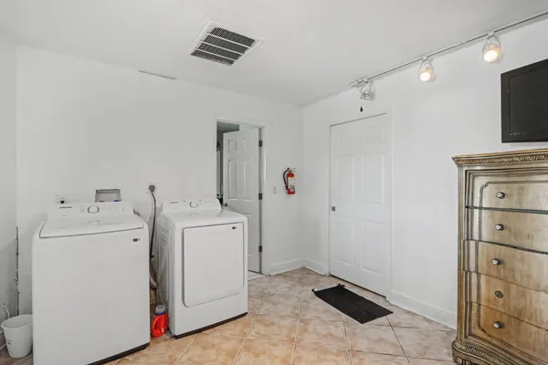 a view of washer and dryer with bathroom in the background
