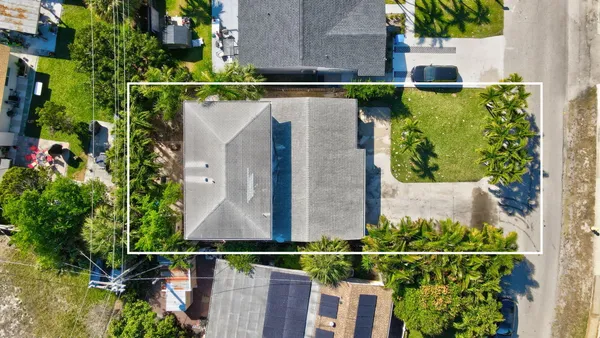 an aerial view of multiple houses with a yard