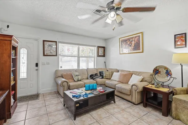 a living room with furniture a chandelier and a window