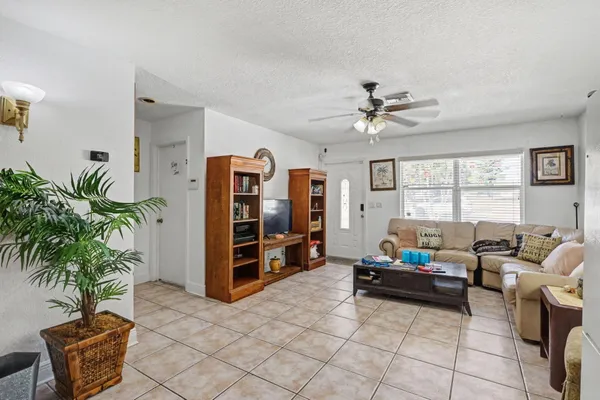 a living room with furniture a window and a potted plant