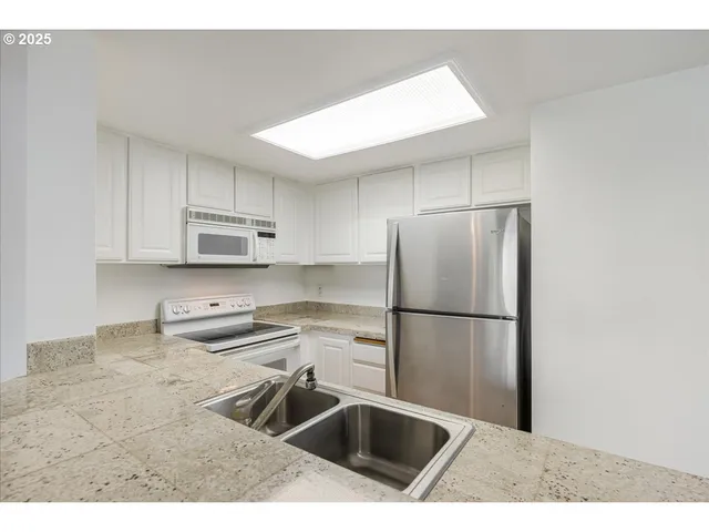 a kitchen with a refrigerator sink and cabinets