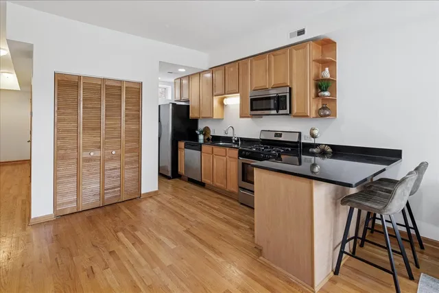 a kitchen with granite countertop a stove a sink and a microwave