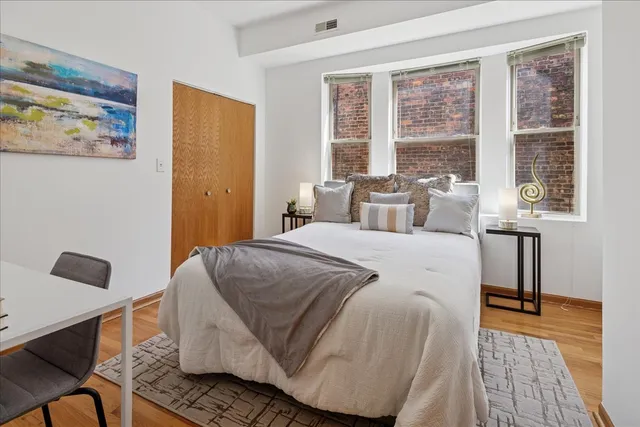 a bedroom with a bed and wooden floor