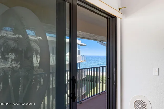 a bed sitting in a bedroom next to a window and a chandelier