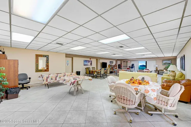 a living room with patio furniture and a chandelier