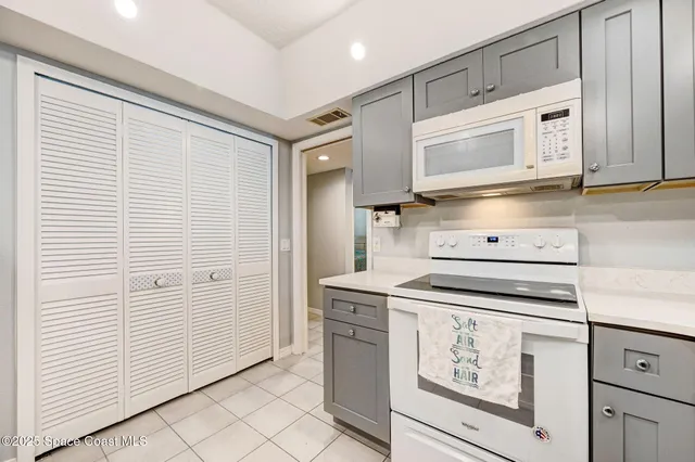 a kitchen with a refrigerator a sink and white cabinets