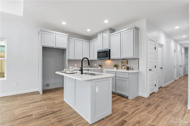 a kitchen with kitchen island a sink stainless steel appliances and cabinets