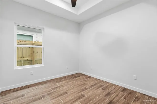 an empty room with a window and wooden floor
