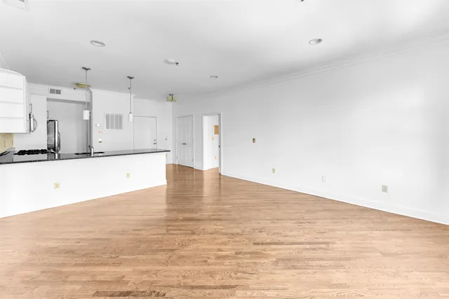 a view of a kitchen with kitchen island white cabinets and wooden floor
