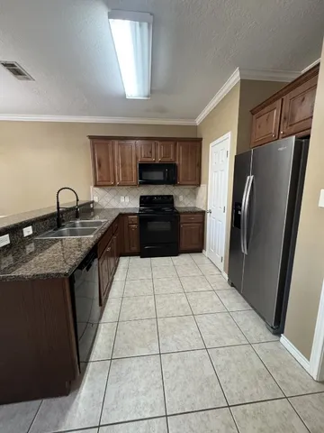 a kitchen with stainless steel appliances granite countertop a refrigerator and a sink