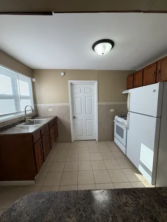 a kitchen with a sink a refrigerator and a stove