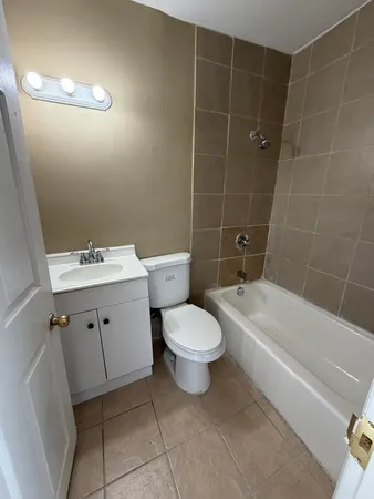 a bathroom with a toilet a sink a mirror and bathtub