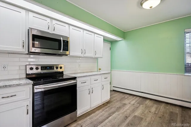 a kitchen with stainless steel appliances white cabinets and a stove top oven