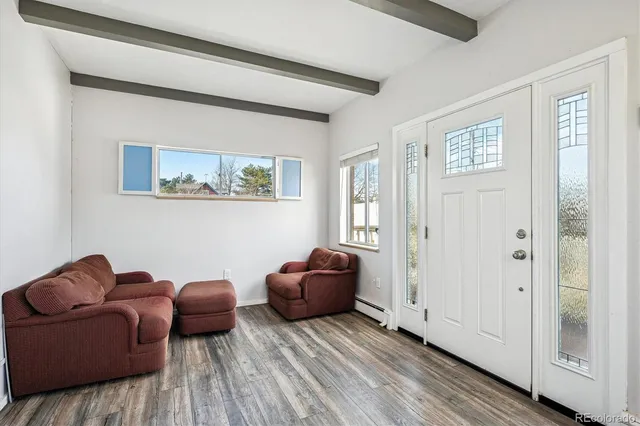 a view of a livingroom with wooden floor and staircase