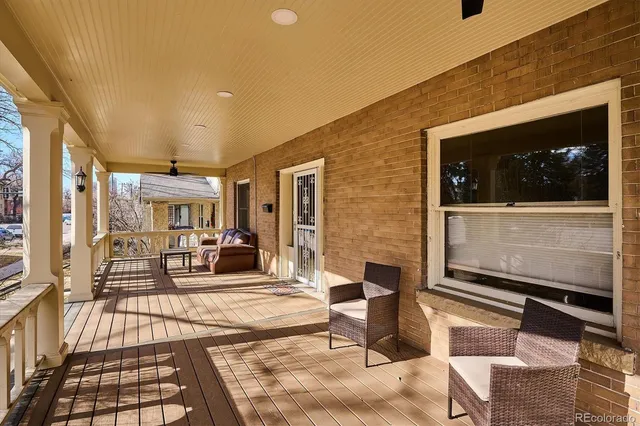 a living room with furniture a flat screen tv and floor to ceiling window