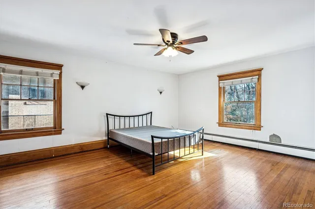 a room with a wooden floor and windows