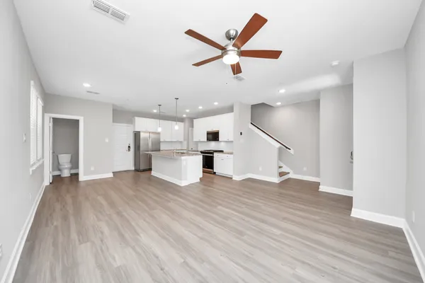 a living room with kitchen island wooden floor and a window