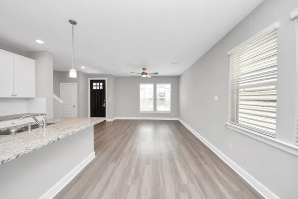 a view of a big room with wooden floor and windows