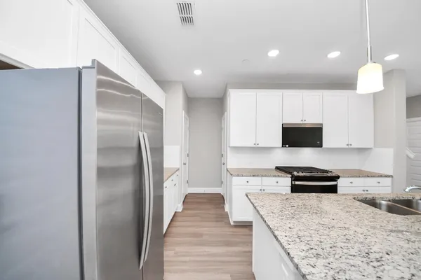 a kitchen with stainless steel appliances granite countertop a sink stove and wooden floor