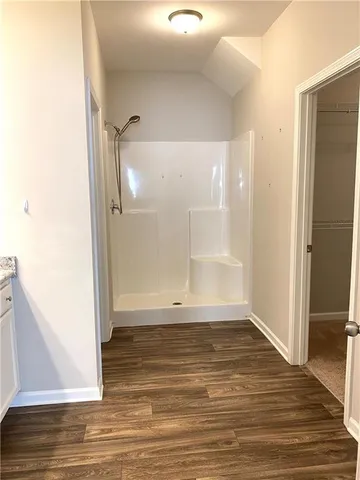 an empty room with wooden floor and entrance