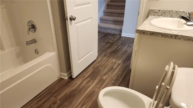a bathroom with a granite countertop toilet sink and mirror