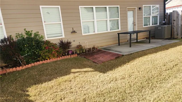 a view of house with wooden deck and outdoor seating