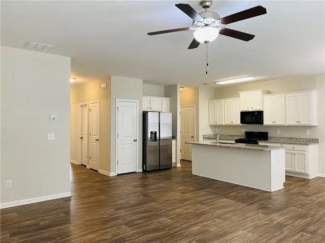 a view of kitchen with stainless steel appliances refrigerator stove microwave and cabinets