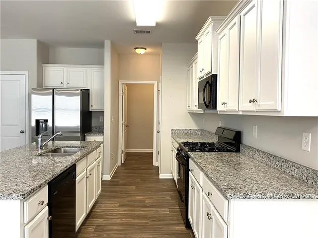 a kitchen with stainless steel appliances granite countertop a stove a sink and a refrigerator