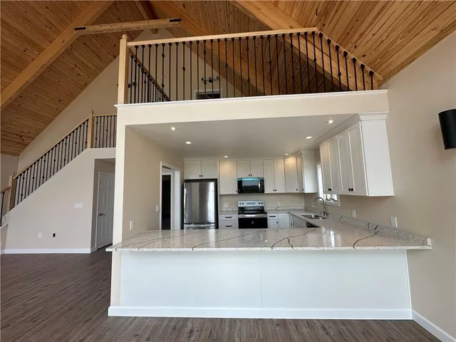 a view of kitchen with stainless steel appliances kitchen island sink refrigerator and stove