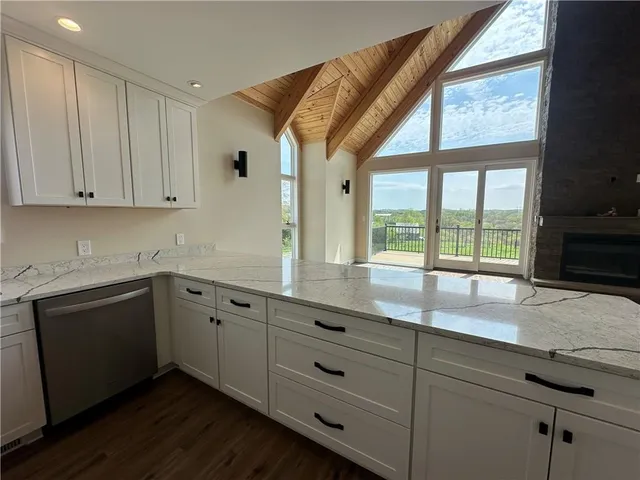 a kitchen with granite countertop white cabinets and a large window