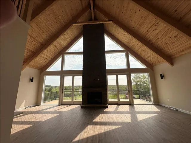 a view of an empty room with wooden floor and a floor to ceiling window