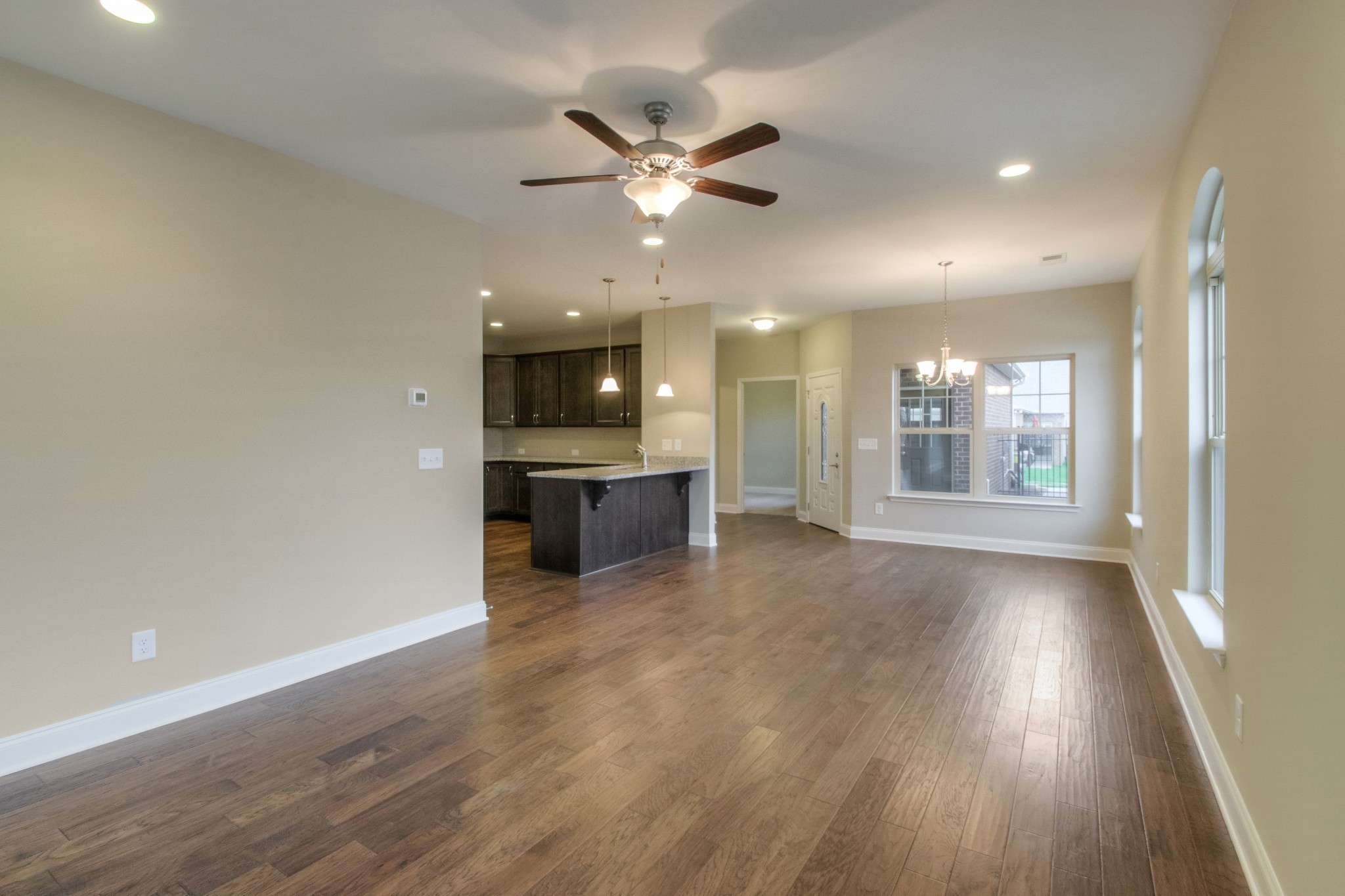 334 Buckner Cir Mount Mount Juliet, TN 37122 - Photo 4 of 40 a view of an empty room with a kitchen and wooden floor