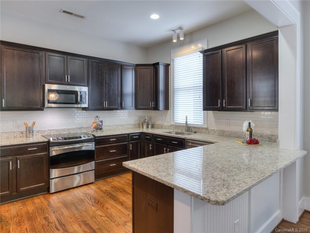 209 Coneflower Place Fort Mill, SC 29708 - Photo 18 of 48 a kitchen with stainless steel appliances granite countertop wooden cabinets a sink and a stove