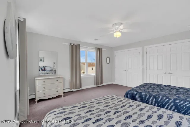 a bedroom with a bed and a refrigerator