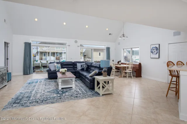 a living room with lots of furniture and view of kitchen
