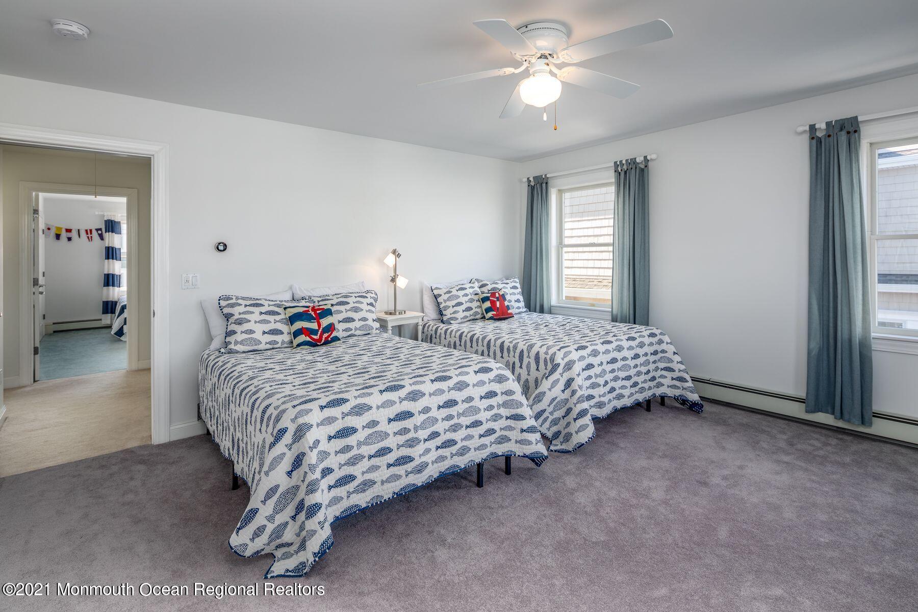 304 Cutter Lane Mantoloking, NJ 08738 - Photo 35 of 54 a bedroom with a bed and a chandelier