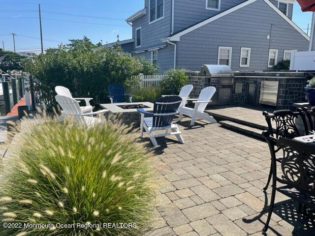 304 Cutter Lane Mantoloking, NJ 08738 - Photo 42 of 54 a view of a patio with table and chairs and potted plants