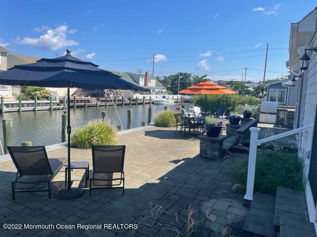 304 Cutter Lane Mantoloking, NJ 08738 - Photo 46 of 54 a patio with a table and chairs under an umbrella
