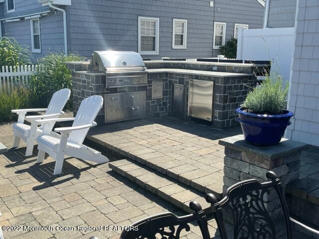 304 Cutter Lane Mantoloking, NJ 08738 - Photo 47 of 54 a roof deck with a dining table and chairs with potted plants