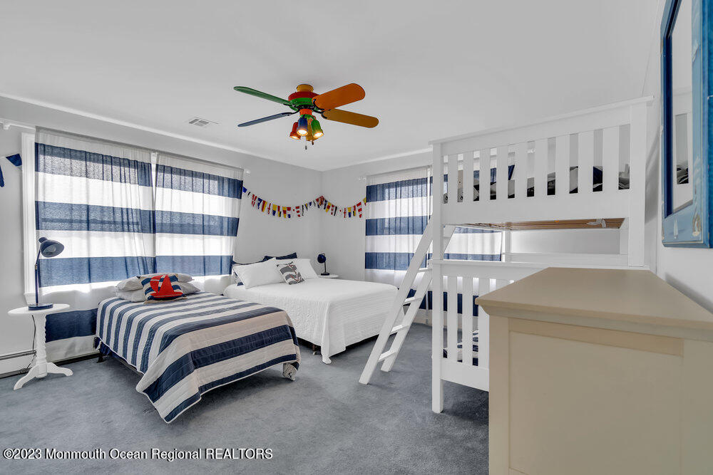 304 Cutter Lane Mantoloking, NJ 08738 - Photo 10 of 54 a bedroom with a bed and a chandelier