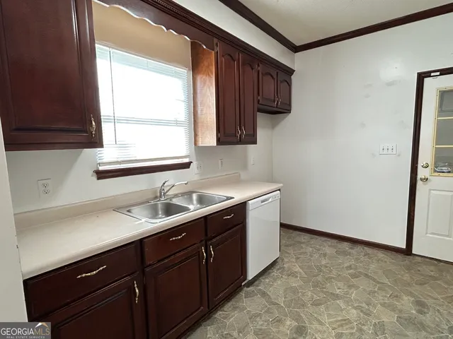 a kitchen with a sink cabinets and a window