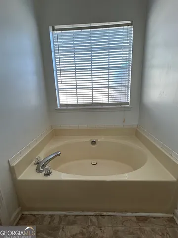 a bathroom with a bathtub and next to a window