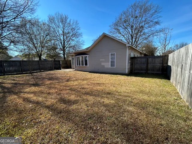 a house view with wooden fence and trees