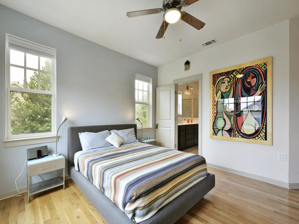 3900 Threadgill Street, Unit 32 Austin, TX 78723 - Photo 20 of 30 Natural light streams through multiple windows onto the classic hardwood flooring.