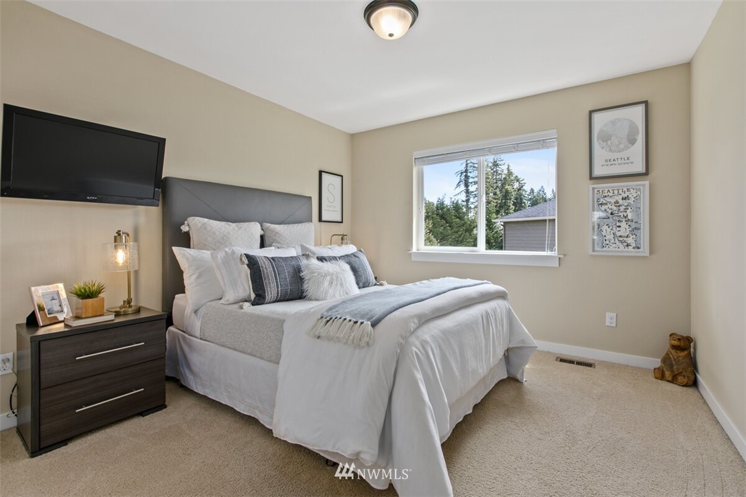 21703 31st Drive Southeast Bothell, WA 98021 - Photo 19 of 34 a bedroom with a bed and a flat tv screen on dresser